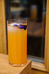 Refreshing orange cocktail with edible flower garnish