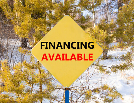 Financing available symbol. Concept words Financing available on beautiful yellow road sign. Beautiful forest snow blue sky background. Business financing available concept. Copy space.