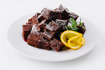 Chocolate brownie pieces on white plate