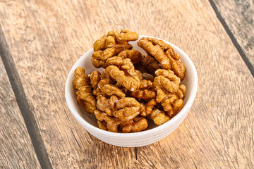 Cracked unshelled walnut in the bowl