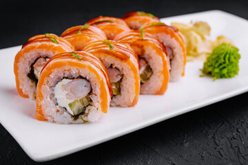 Delicious salmon sushi roll on white plate