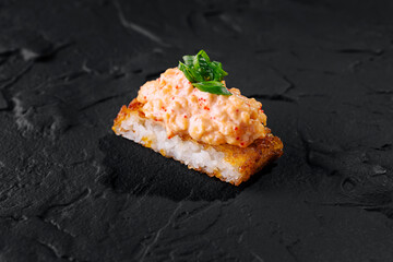 Delectable spicy sushi roll on slate background