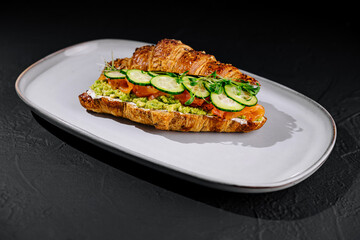 Gourmet salmon avocado croissant sandwich