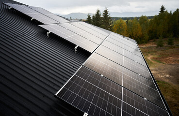 Solar photovoltaic batteries on a roof. Installation of solar panels on a top of house in forest....