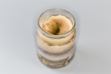 Pickled herring fillets in open jar on gray background - 787046099