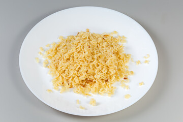 Boiled alphabet pasta on white dish on a gray background