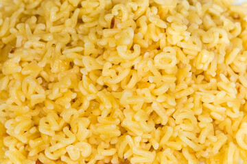 Heap of boiled alphabet pasta, top view in selective focus
