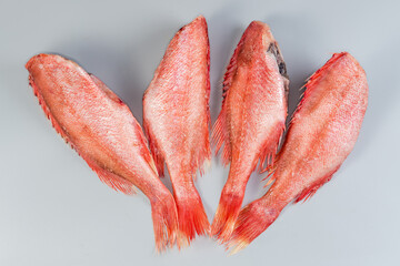 Frozen redfish carcasses with hoarfrost on gray surface, top view