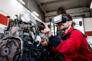 Experienced mechanic using modern technologies and Virtual Reality glasses while repairing engine in workshop.
