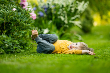 Adorable little boy having fun outdoors on sunny summer day. Kid running outdoors. Child exploring nature. Summer activities for kids.
