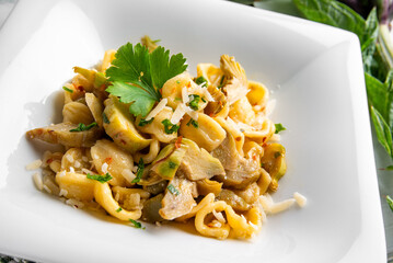 Piatto di deliziose orecchiette condite con carciofi, pasta italiana vegetariana, cibo mediterraneo  - 787052214