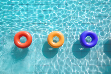 AI generated image, Summer time concept ,Colorful rubber rings floating in bright and clean swimming pool, top view, view from above