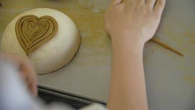 Close-up of child's hands sculping from modeling clay in a workshop.