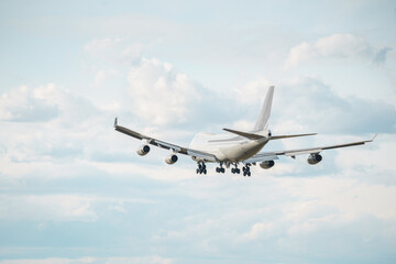 Rear view of a massive cargo plane is preparing to land amidst the clouds. Landing airplane.
