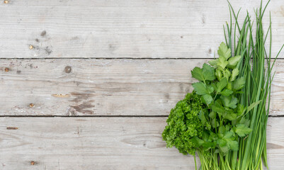 Bunch of​ fresh parsley, chives and spring onion on a light wooden background
