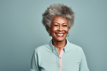 Portrait of a merry afro-american woman in her 80s donning a classy polo shirt over pastel gray background