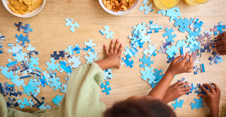 Close Up Overhead Shot Of Children Indoors At Home Doing Jigsaw Puzzle Together