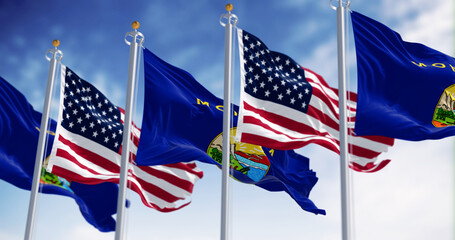 Montana state flags waving in the wind with the American flag on a clear day - 787064687