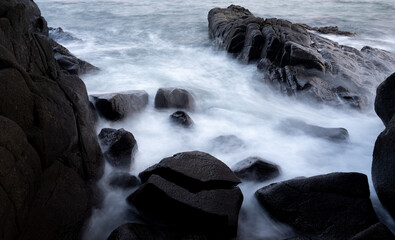 Scenic view of sea waves against the rocky beach