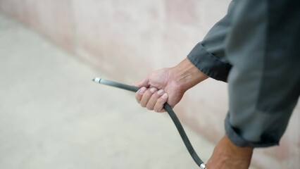 Close-up of hands operating a fire extinguisher during the accident. Using the balloon of powder extinguisher in case of fire, unrecognizable person. Stream comes out of the hose