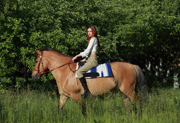 Equestrian woman ride horseback in summer meadow