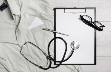 Health care template. Blank medical clipboard, stethoscope, glasses and pen. Flat lay.