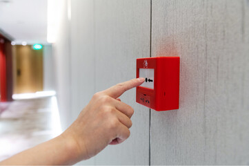 People hand pressing fire alarm