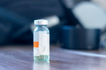 A small bottle labeled vaccine containing a liquid solution