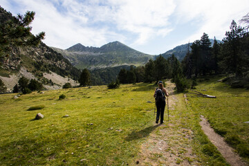 Fototapeta na wymiar Young hiker woman in Vall de Boi, Aiguestortes and Sant Maurici National Park, Spain