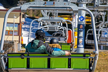 ski lift with dad and child climbs the snowy slope. Active recreation