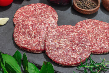 Raw burger patties. Fresh meat cutlets, spices, vegetables, herbs. Homemade American classic