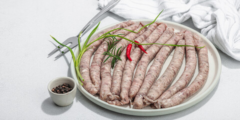 Raw pork sausages ready to cook in barbecue. Spices and herbs, traditional ingredient for picnic