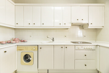 Frontal image of an old-fashioned kitchen with white lacquered furniture and integrated appliances - obrazy, fototapety, plakaty