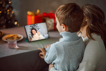 Happy young woman with little son, talking with friends on virtual zoom video call,
