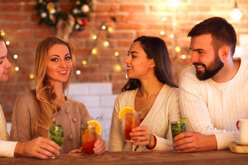 Young men and women drinking cocktail at party