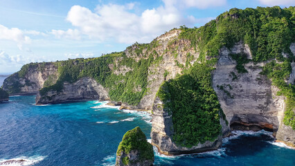 Nusa Penida, Indonesia. Rocky area, covered with vegetation, washed by turquoise sea. Travel...
