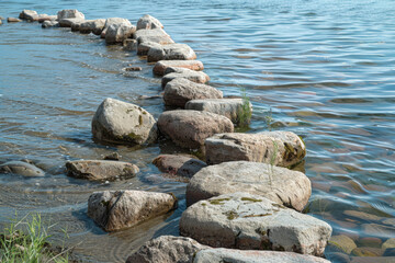 A rocky shoreline with a body of water in the background