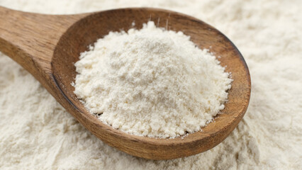 Flour falls in wooden spoon 