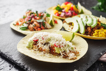 set of delicious fresh colorful tacos on a dark background