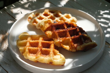 Croffle is croissant waffle. is a croissant that is processed with a waffle maker. This food is popular in Indonesia. served on a white ceramic plate. 