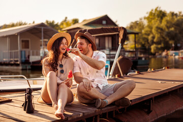 Couple spending summer day by the river - obrazy, fototapety, plakaty