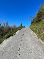 Empty asphalt road on the Camino del Norte in Spain leading up a hill on a sunny day