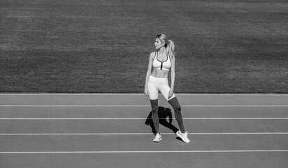 Woman on stadium track. Sportswoman wearing sportswear. Black and white