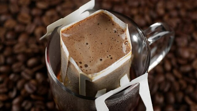 Drip coffee. Pouring hot water in glass with drip coffee bag 