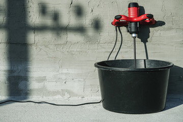 handheld electric concrete mixer on construction site