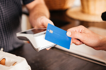 Close-Up of Hand Holding Credit Card for Payment at Grocery Store Checkout