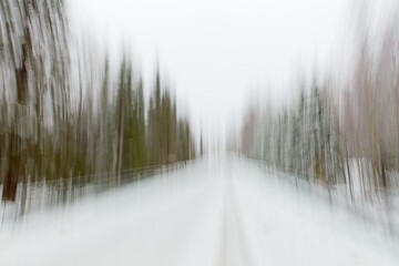 Abstract of road in forest with tire tracks in winter with snow covering the ground made by using...