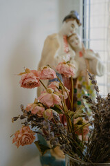 Dried lavender and rose. Dry flowers with a couple statuette on the background.