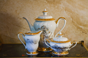Porcelain tea set on a glass table.