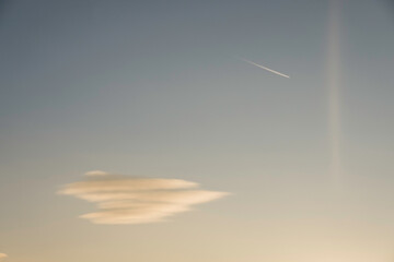 single soft colorful cloud with a aeroplane on the sky during sundown